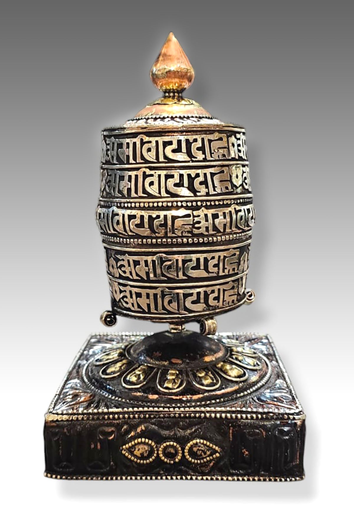 Silver colored ovel Shaped Copper Prayer Wheel in Square base, 9"